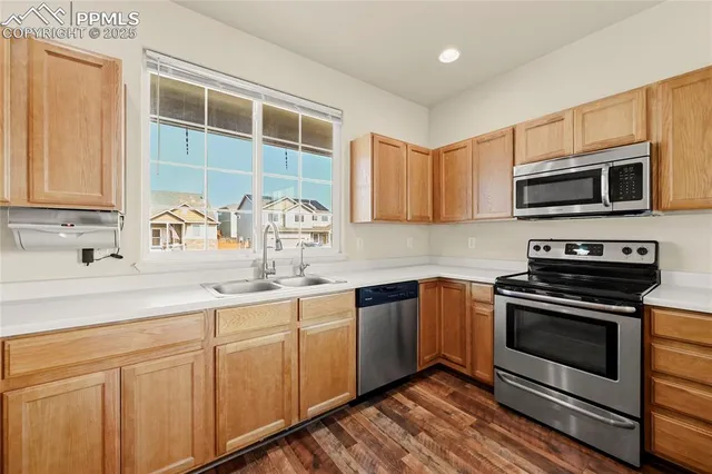 a kitchen with stainless steel appliances granite countertop a stove a sink and a microwave