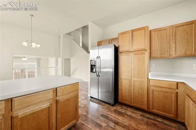 a kitchen with kitchen island white cabinets and refrigerator