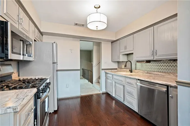 a kitchen with stainless steel appliances granite countertop a sink stove and refrigerator