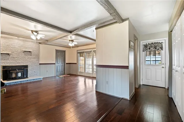 a view of a livingroom with wooden floor a fireplace and window
