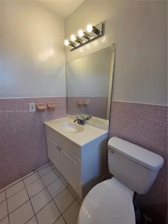 a bathroom with a sink a toilet mirror and vanity
