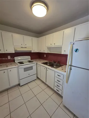 a kitchen with cabinets appliances and a sink