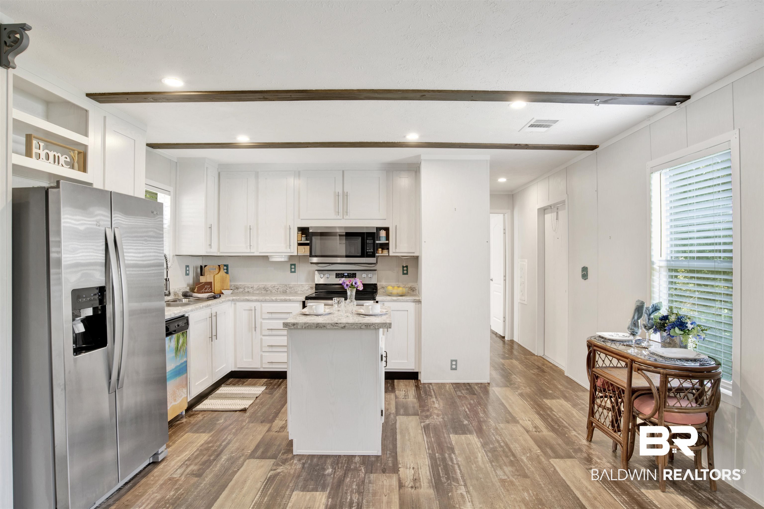 1411 Ridgewood Drive Lillian, AL 36549 - Photo 13 of 30 Kitchen with appliances with stainless steel finishes, dark wood-type flooring, white cabinetry, and a kitchen island