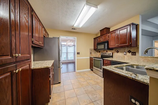 a kitchen with granite countertop stainless steel appliances and wooden cabinets