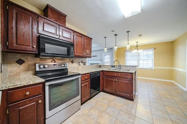 a kitchen with granite countertop a stove microwave and cabinets