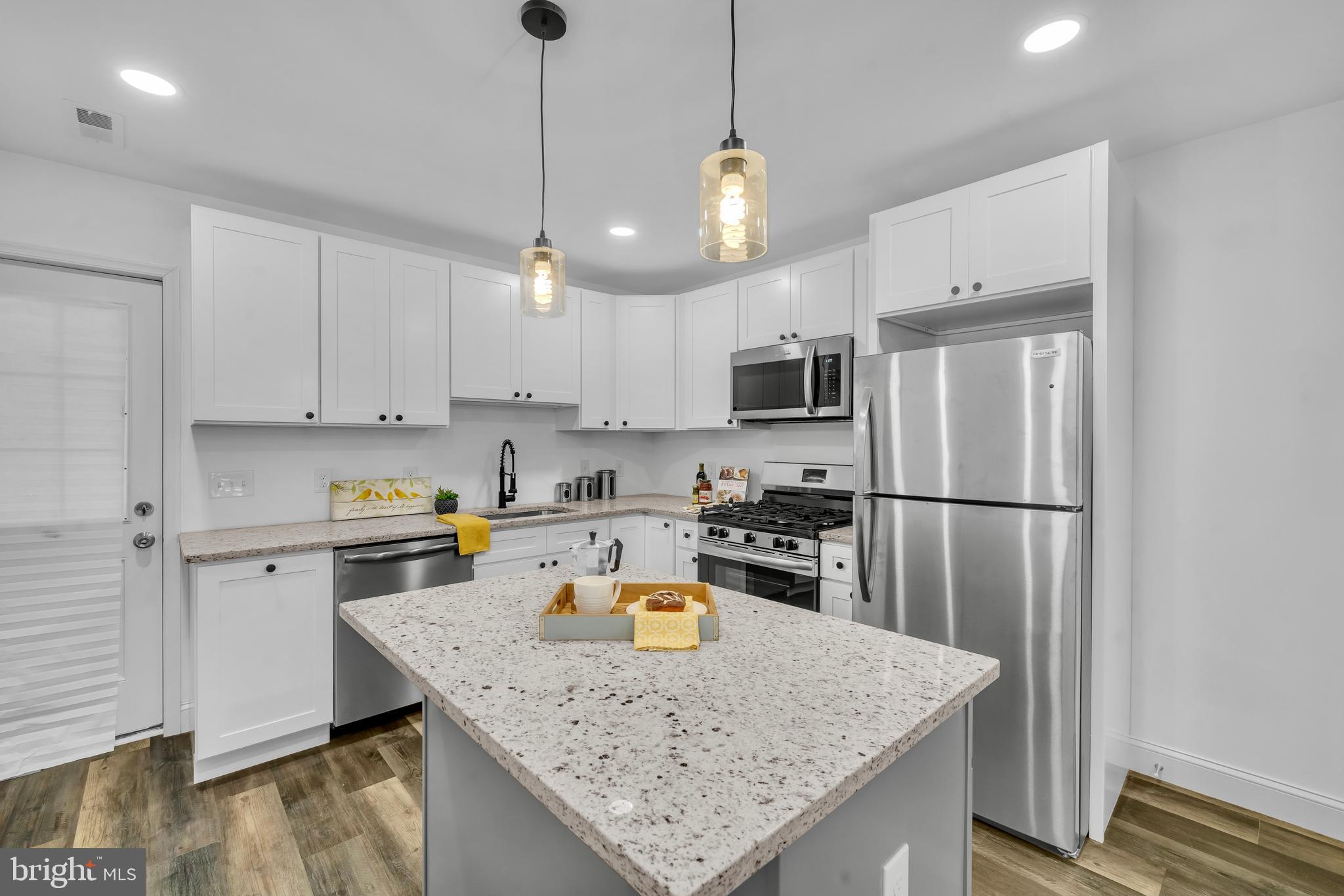 1710 Light Street Baltimore, MD 21230 - Photo 16 of 59 a kitchen with refrigerator a stove a sink a center island and cabinets