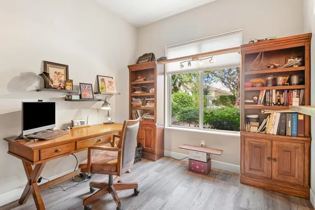 a view of a workspace with furniture and a window