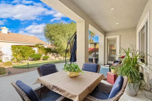 a living room with patio furniture and a potted plant