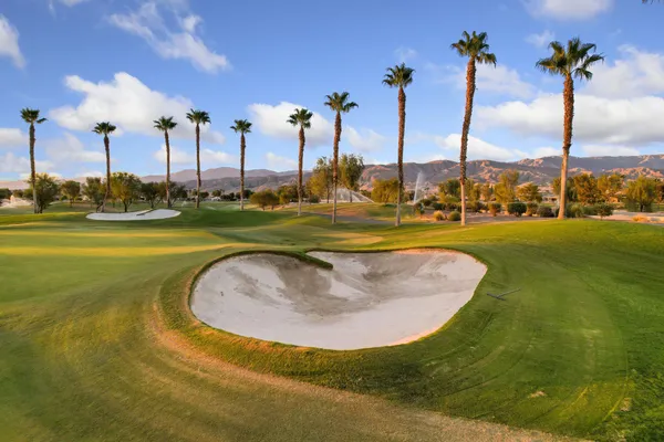 a view of a swimming pool with a lawn chairs under an umbrella