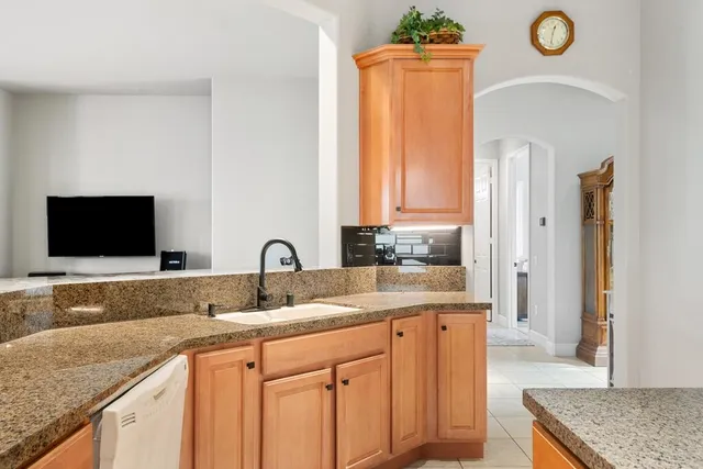 a kitchen with granite countertop a sink and a stove top oven
