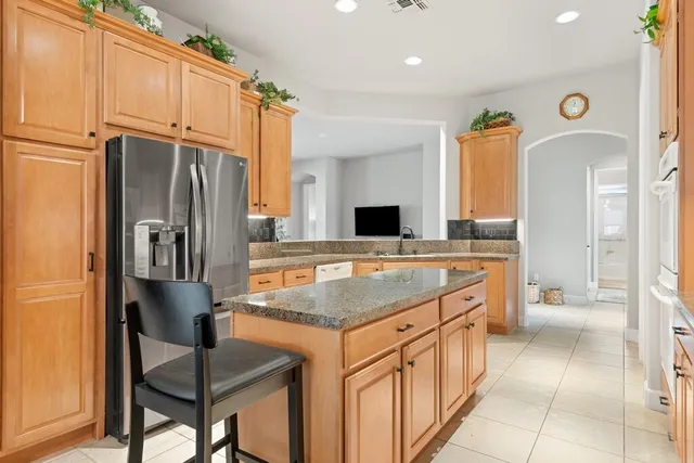 a kitchen with stainless steel appliances granite countertop a refrigerator and a sink