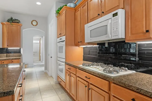 a kitchen with stainless steel appliances granite countertop a stove and a microwave