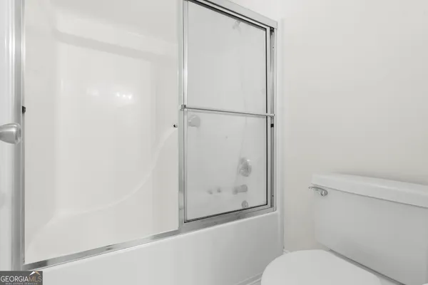 a bathroom with a toilet and a shower