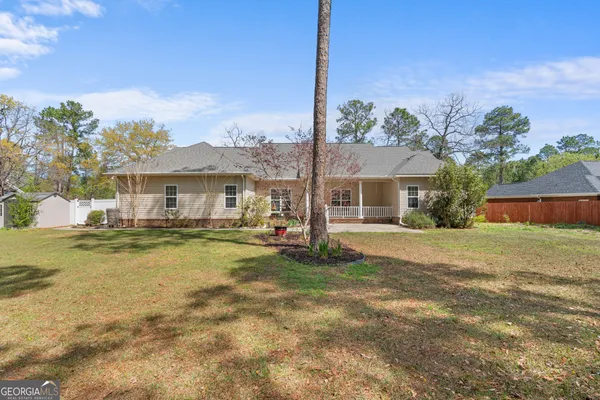 a front view of a house with a garden and lake view