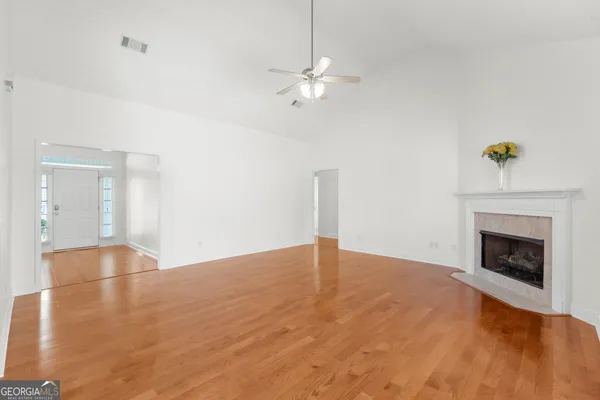 a view of empty room with wooden floor and fireplace