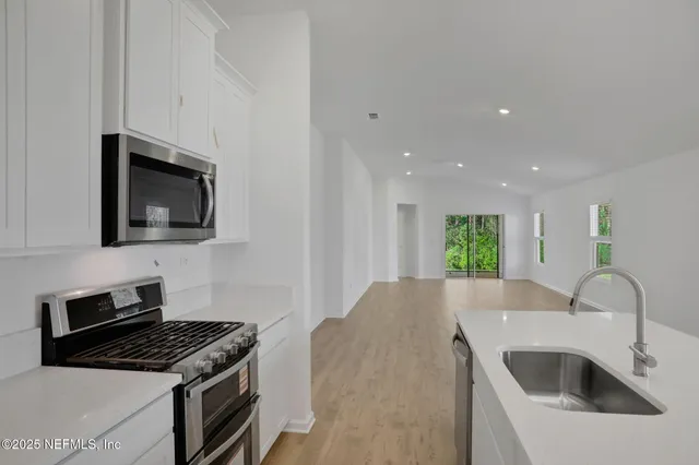 a kitchen with kitchen island a sink stainless steel appliances and cabinets