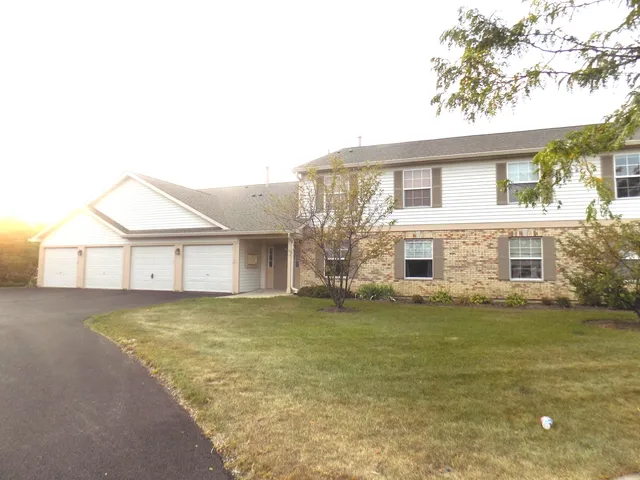 a view of a house with a yard and a garage