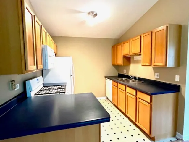 a open kitchen with stainless steel appliances granite countertop a stove a sink and a refrigerator