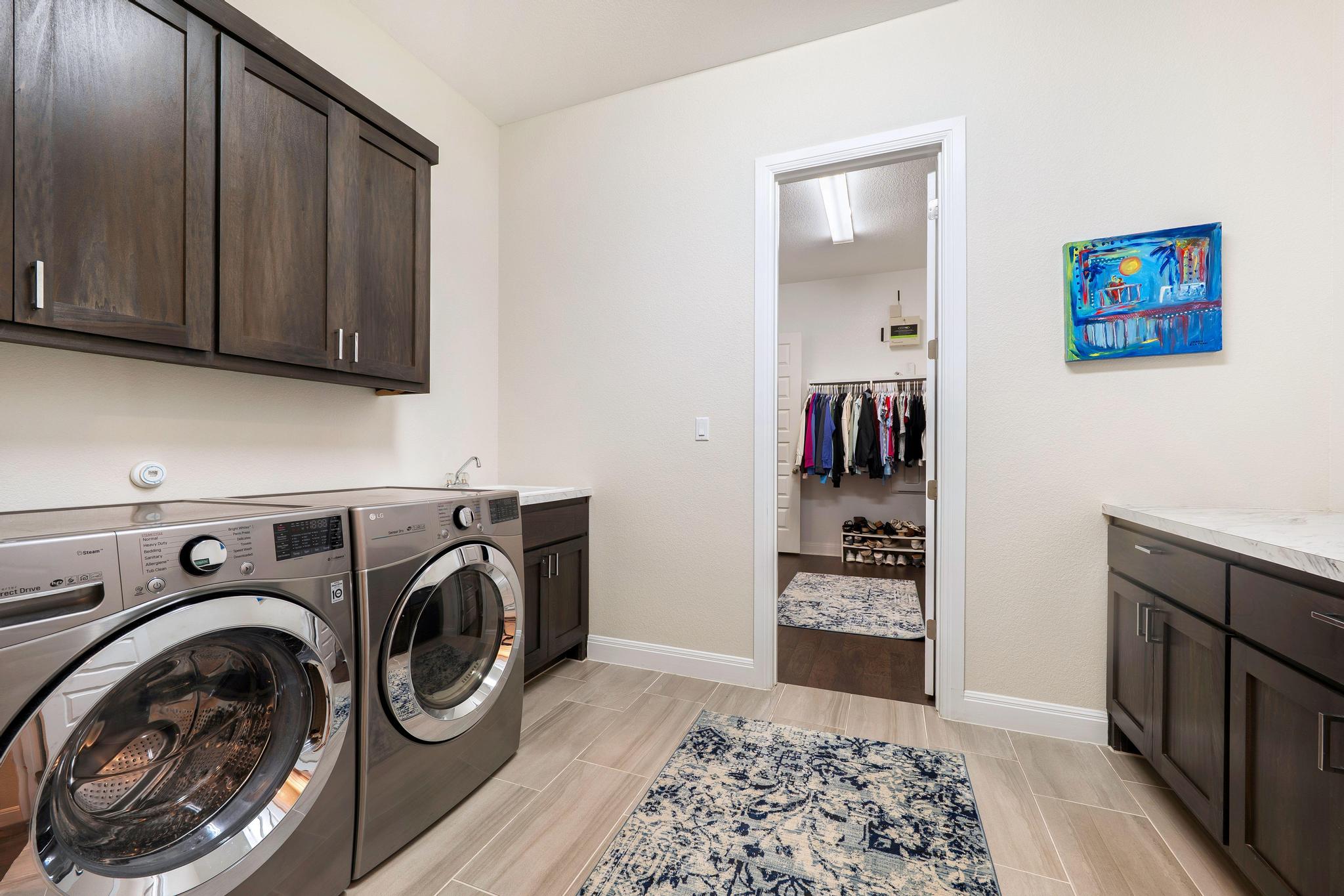 1009 Legacy Crossing Georgetown, TX 78628 - Photo 23 of 40 A dedicated laundry space offers convenience with dual machines and ample storage cabinetry.