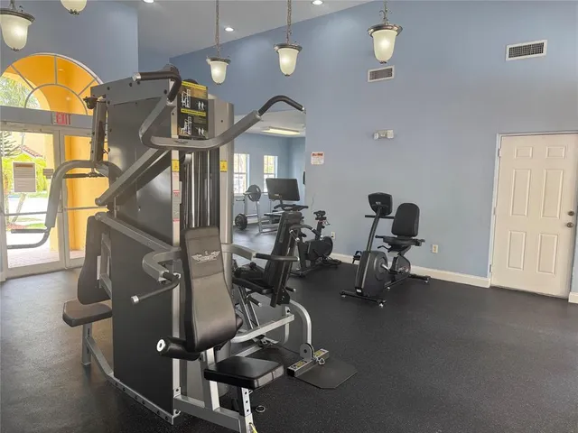 a front view of a house with a yard and palm trees