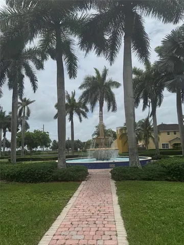 a street with a yard and palm trees