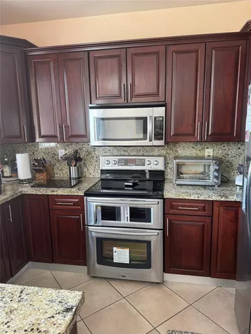 a kitchen with granite countertop wooden cabinets and stainless steel appliances