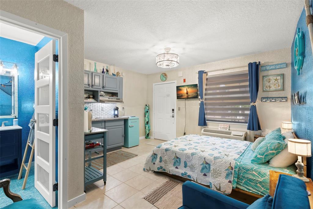 16333 Gulf Boulevard, Unit 113 Redington Beach, FL 33708 - Photo 14 of 40 a bedroom with a bed and a chandelier