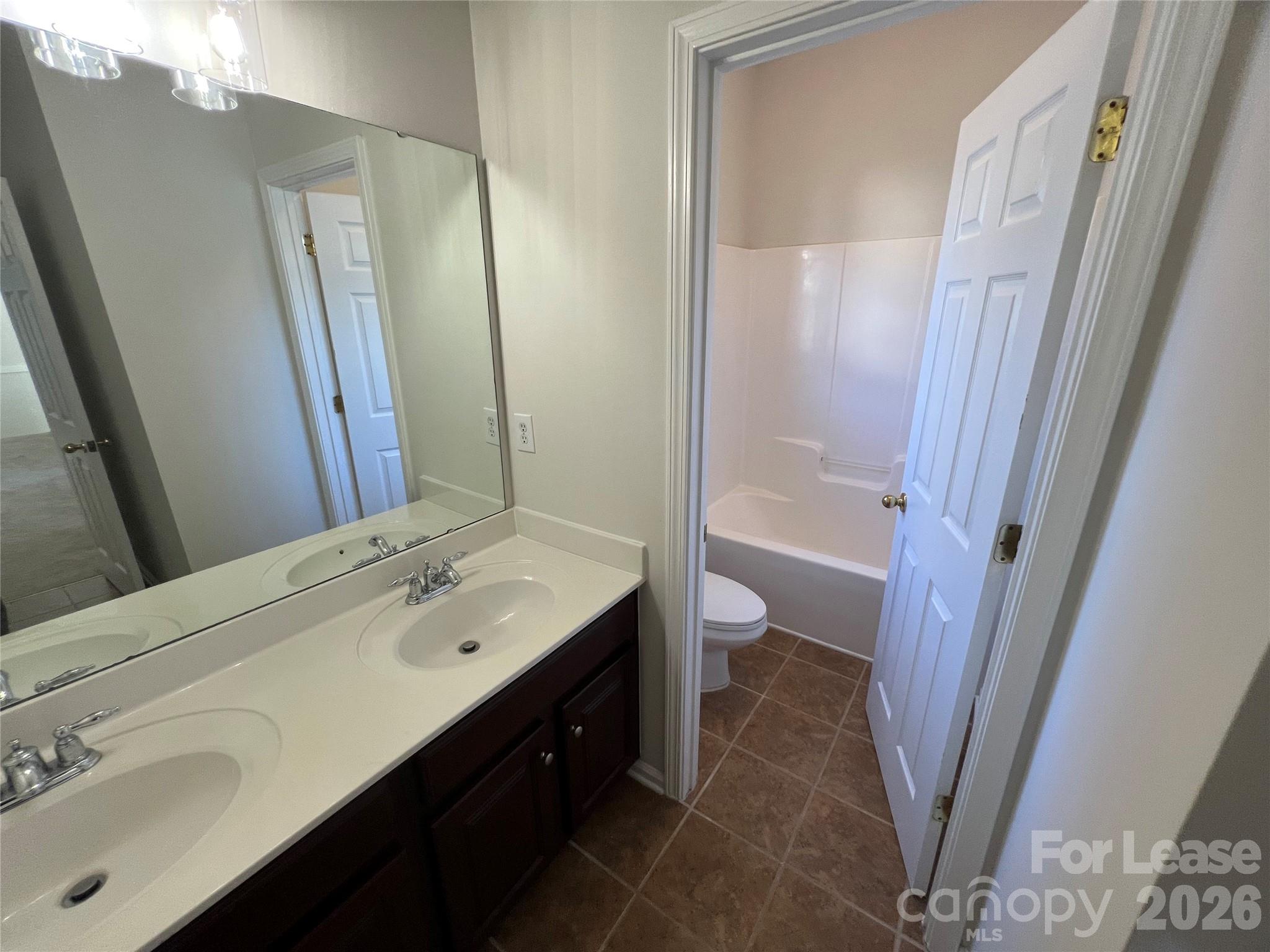 5002 Fine Robe Drive Indian Trail, NC 28079 - Photo 24 of 25 a bathroom with a sink a toilet a tub and a mirror