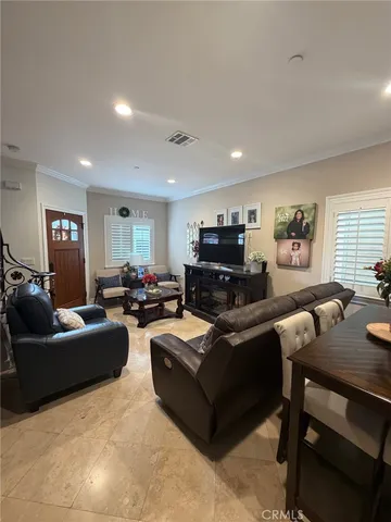 a living room with furniture a flat screen tv and a window
