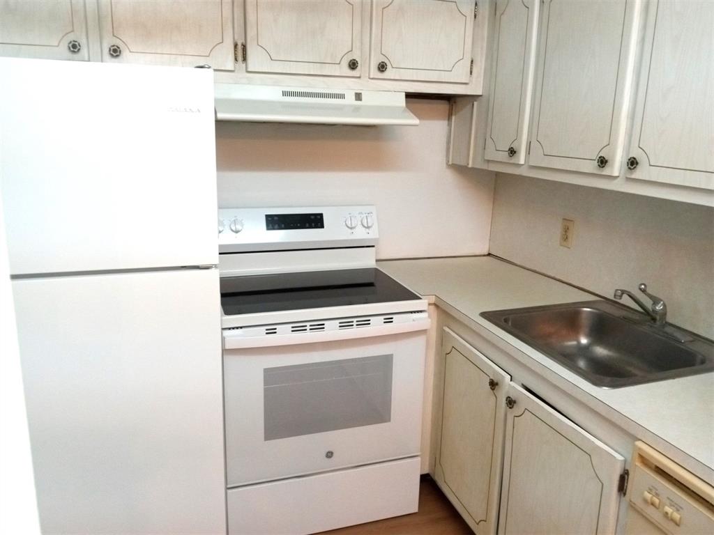 West Deerfield Beach Deerfield Beach, FL 33442 - Photo 4 of 22 a kitchen with granite countertop white cabinets and white appliances