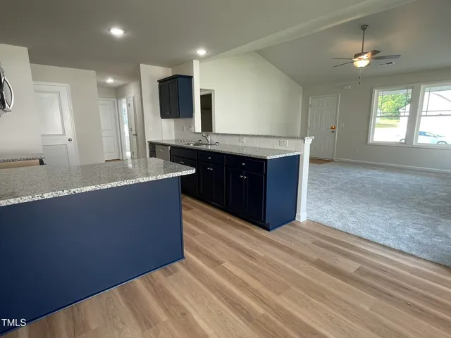 a spacious bathroom with a granite countertop sink a mirror and a bathtub