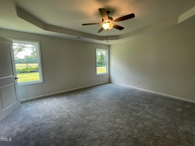 an empty room with a window and a fan