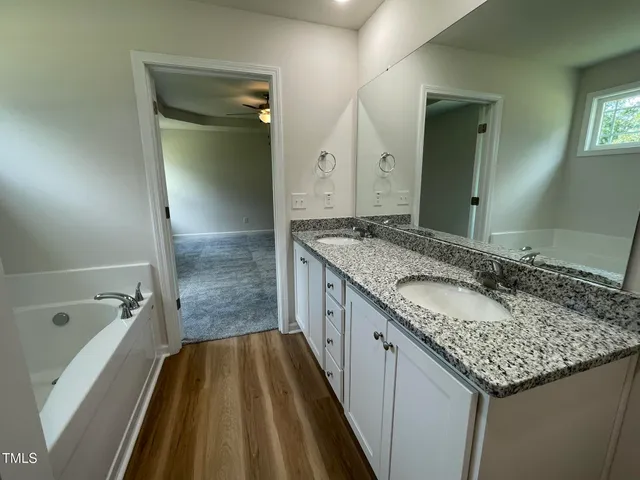 a bathroom with a granite countertop sink and a mirror