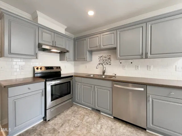 a kitchen with granite countertop white cabinets and a sink