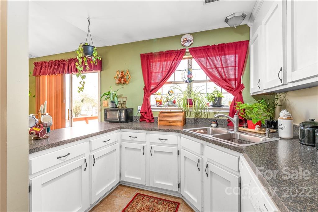 1531 Crestdale Road Rock Hill, SC 29732 - Photo 9 of 20 a kitchen with red cabinets a window and a chandelier