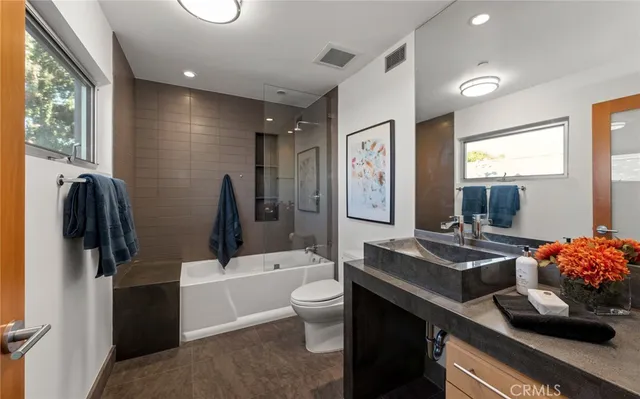 a bedroom with a bed a couch and dresser