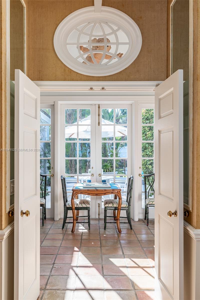 21 South Beach Road Jupiter Island, FL 33455 - Photo 20 of 45 a dining room with a table and chairs next to a window