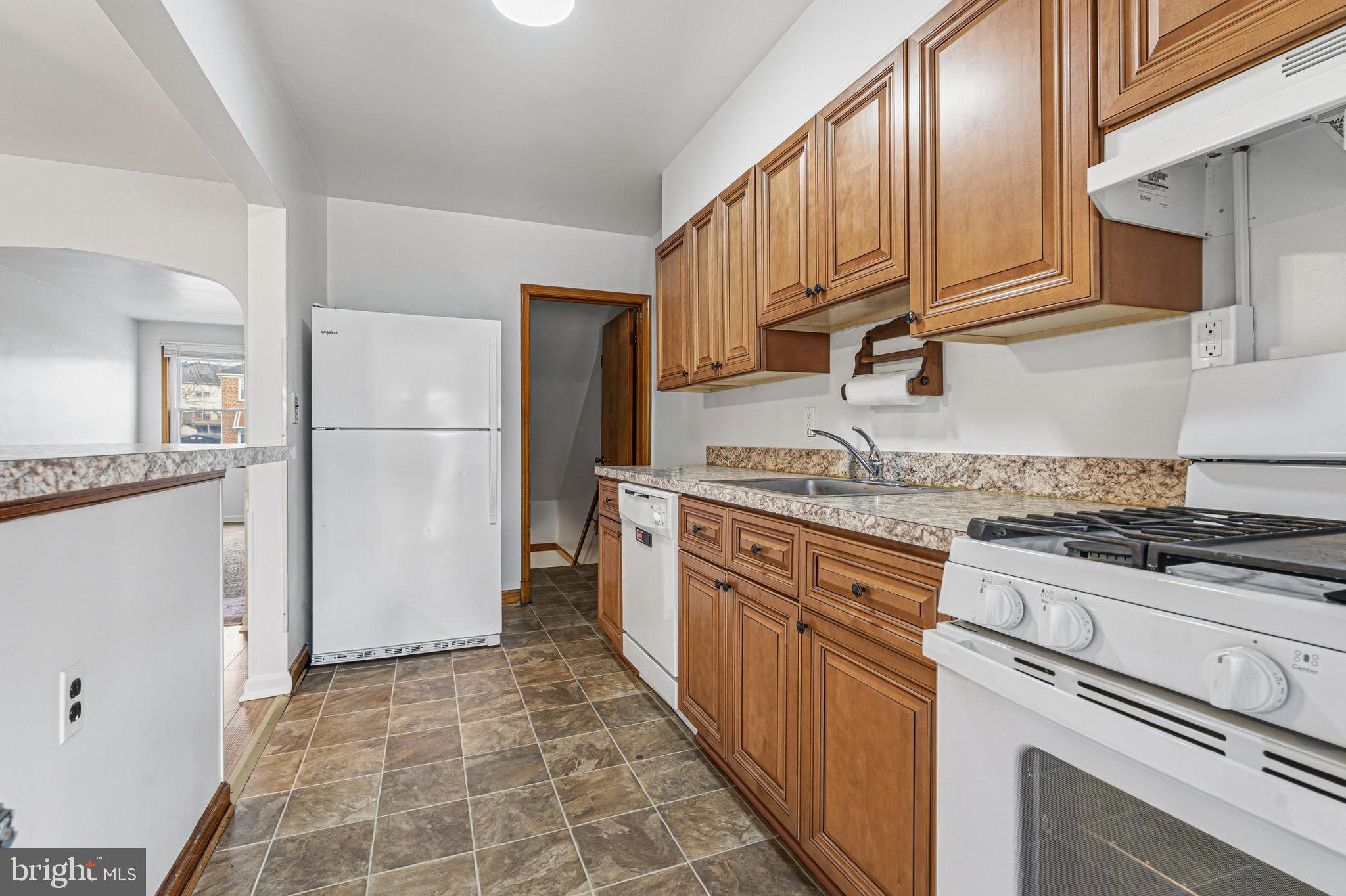 1242 Delbert Avenue Baltimore, MD 21222 - Photo 3 of 34 a kitchen with granite countertop a refrigerator stove top oven and sink