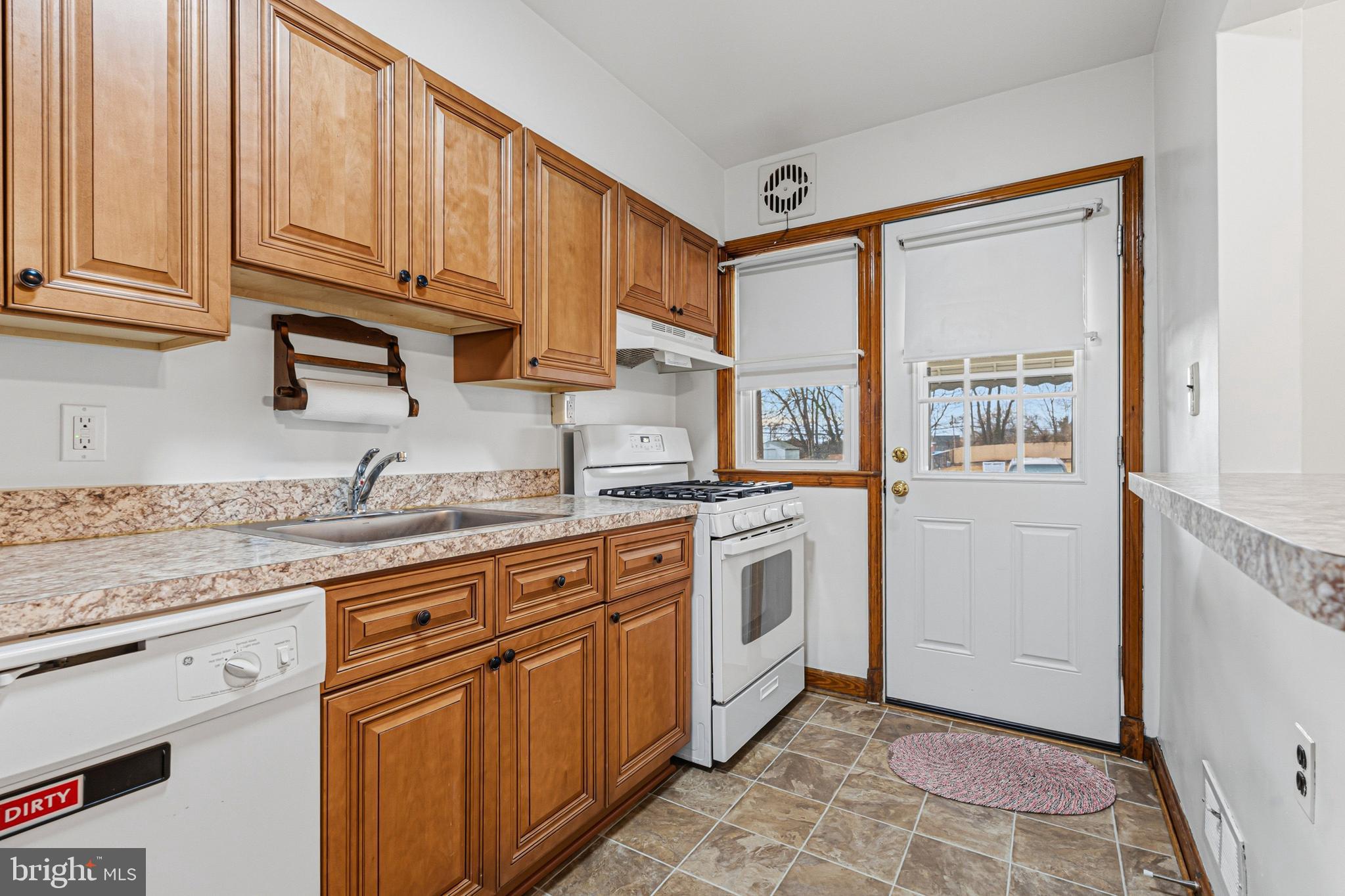 1242 Delbert Avenue Baltimore, MD 21222 - Photo 4 of 34 a kitchen with stainless steel appliances granite countertop a stove a sink and a refrigerator with wooden cabinets