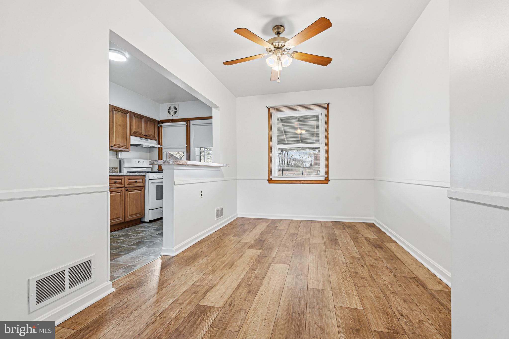 1242 Delbert Avenue Baltimore, MD 21222 - Photo 6 of 34 a view of a kitchen with wooden floor and a ceiling fan
