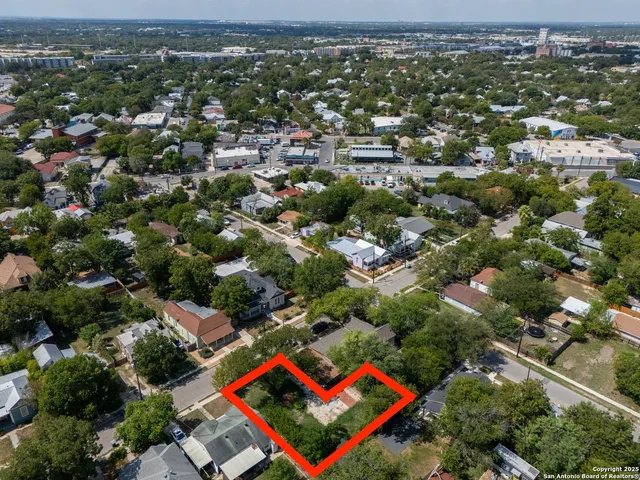 an aerial view of residential houses with outdoor space and trees