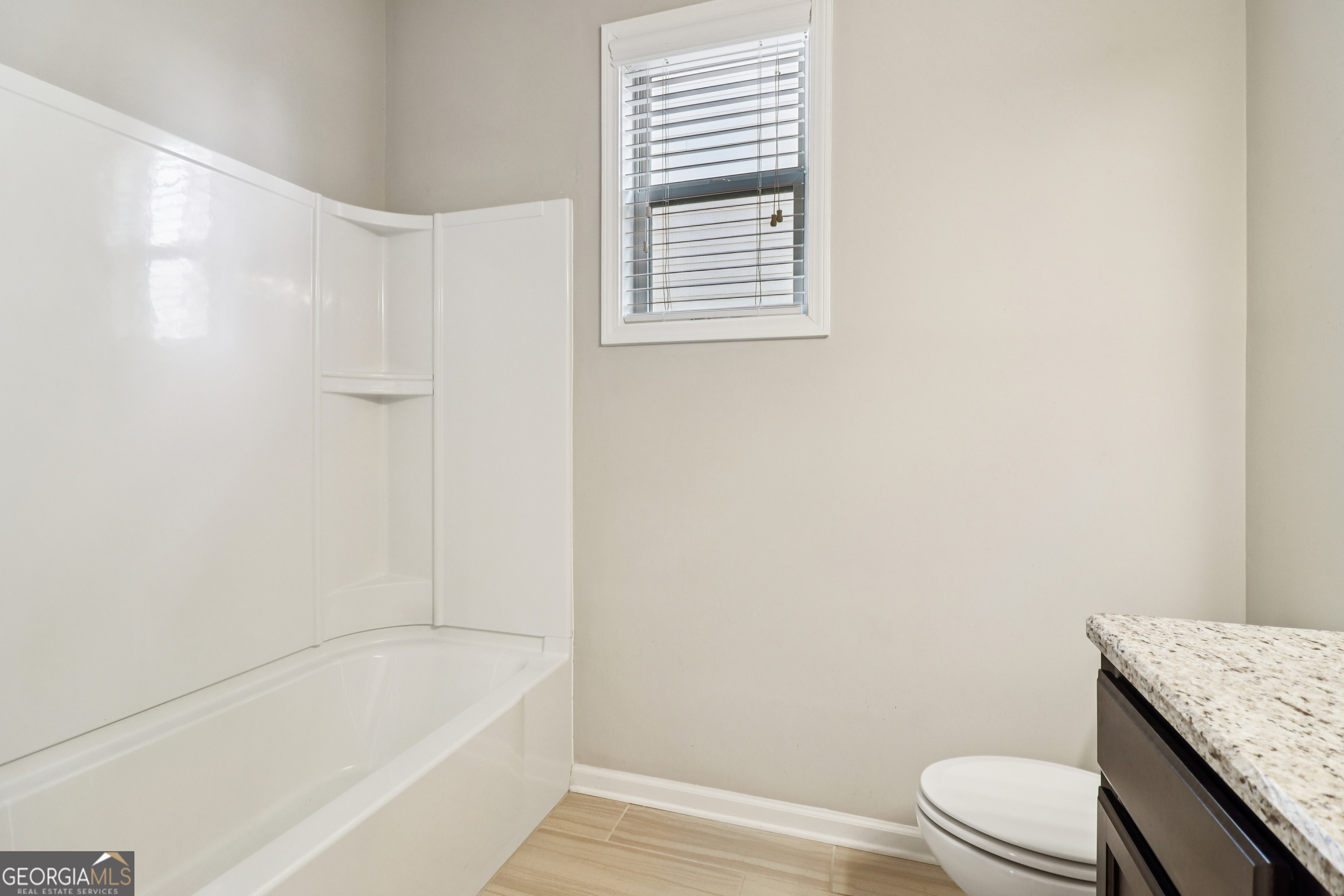 7671 Silk Tree Braselton, GA 30517 - Photo 32 of 92 a bathroom with a granite countertop bathtub toilet and sink