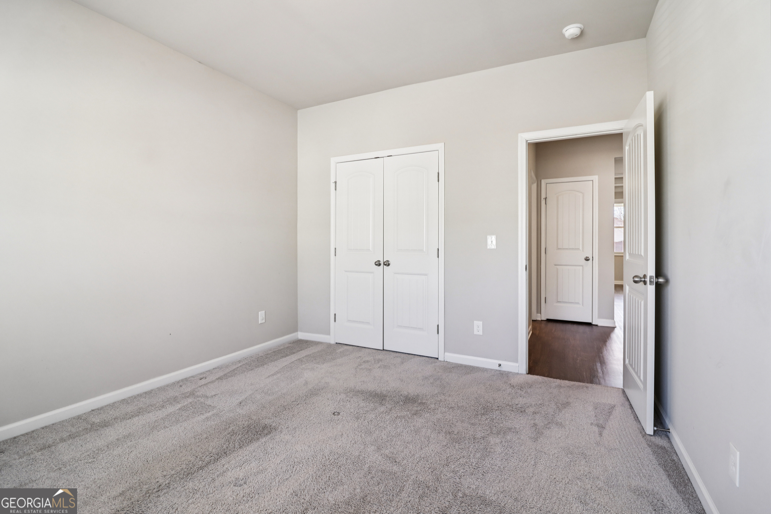 7671 Silk Tree Braselton, GA 30517 - Photo 38 of 92 an empty room with closet and wooden door