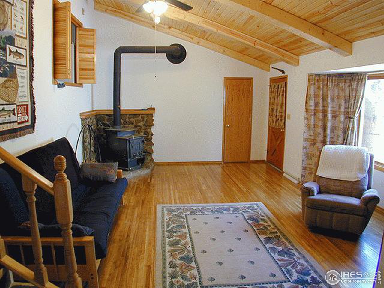 9431 Rist Canyon Road Bellvue, CO 80512 - Photo 8 of 15 a bedroom with a bed and wooden floor