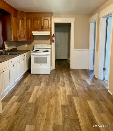 a kitchen with wooden floors and white appliances