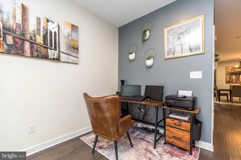 a view of a workspace with furniture and a window