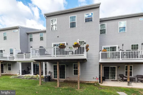 a view of a house with a deck and a yard