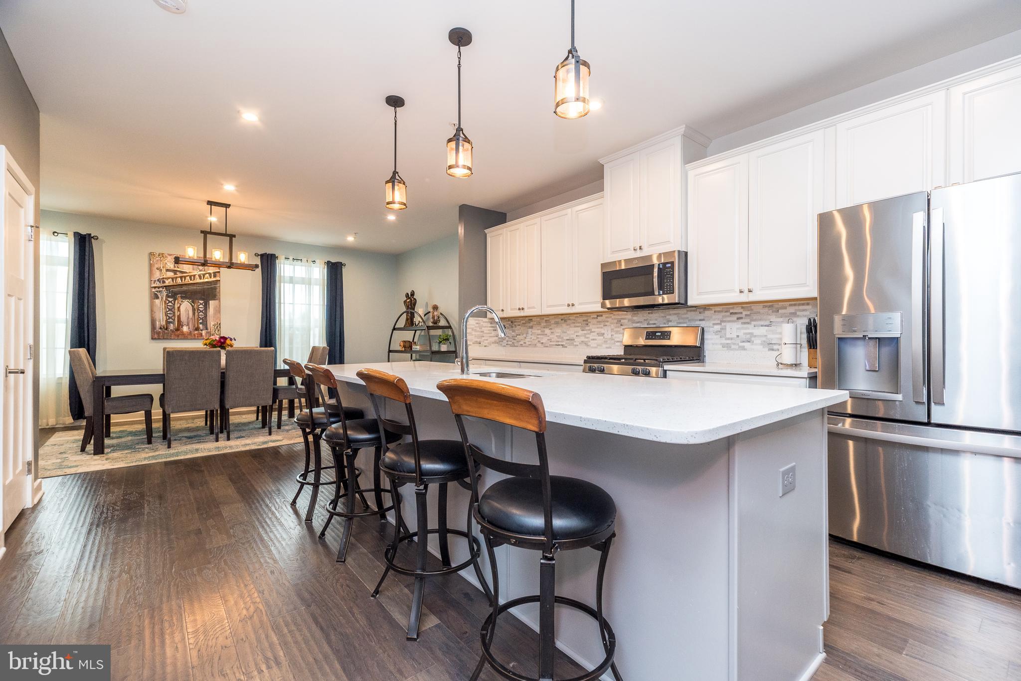 121 Arbor Boulevard Perkasie, PA 18944 - Photo 5 of 39 a kitchen with stainless steel appliances a dining table chairs refrigerator and microwave