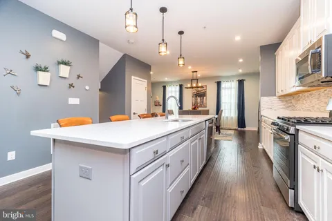 a large kitchen with stainless steel appliances kitchen island granite countertop a large center island and a stove top oven