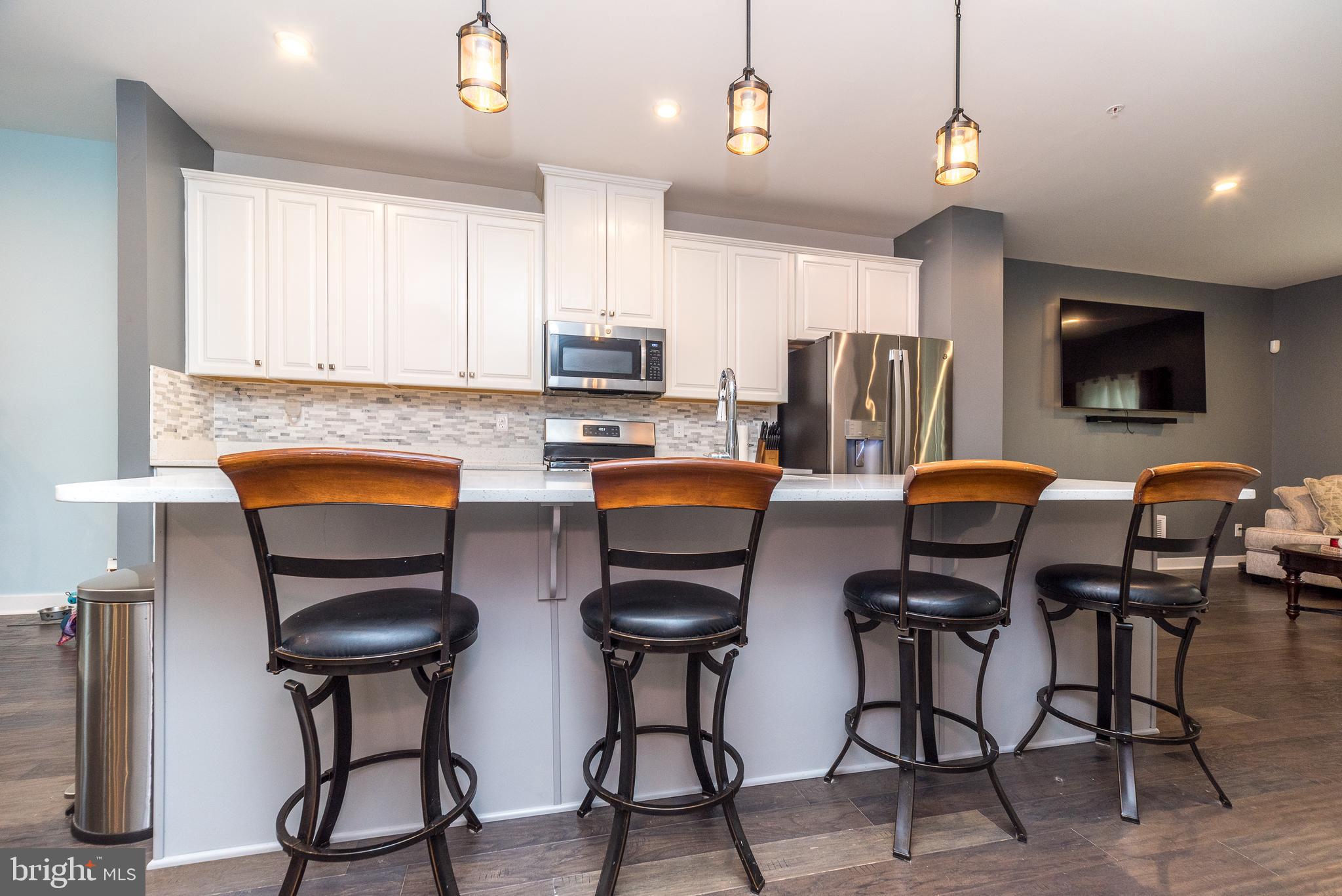 121 Arbor Boulevard Perkasie, PA 18944 - Photo 9 of 39 a kitchen with stainless steel appliances a table chairs refrigerator and microwave